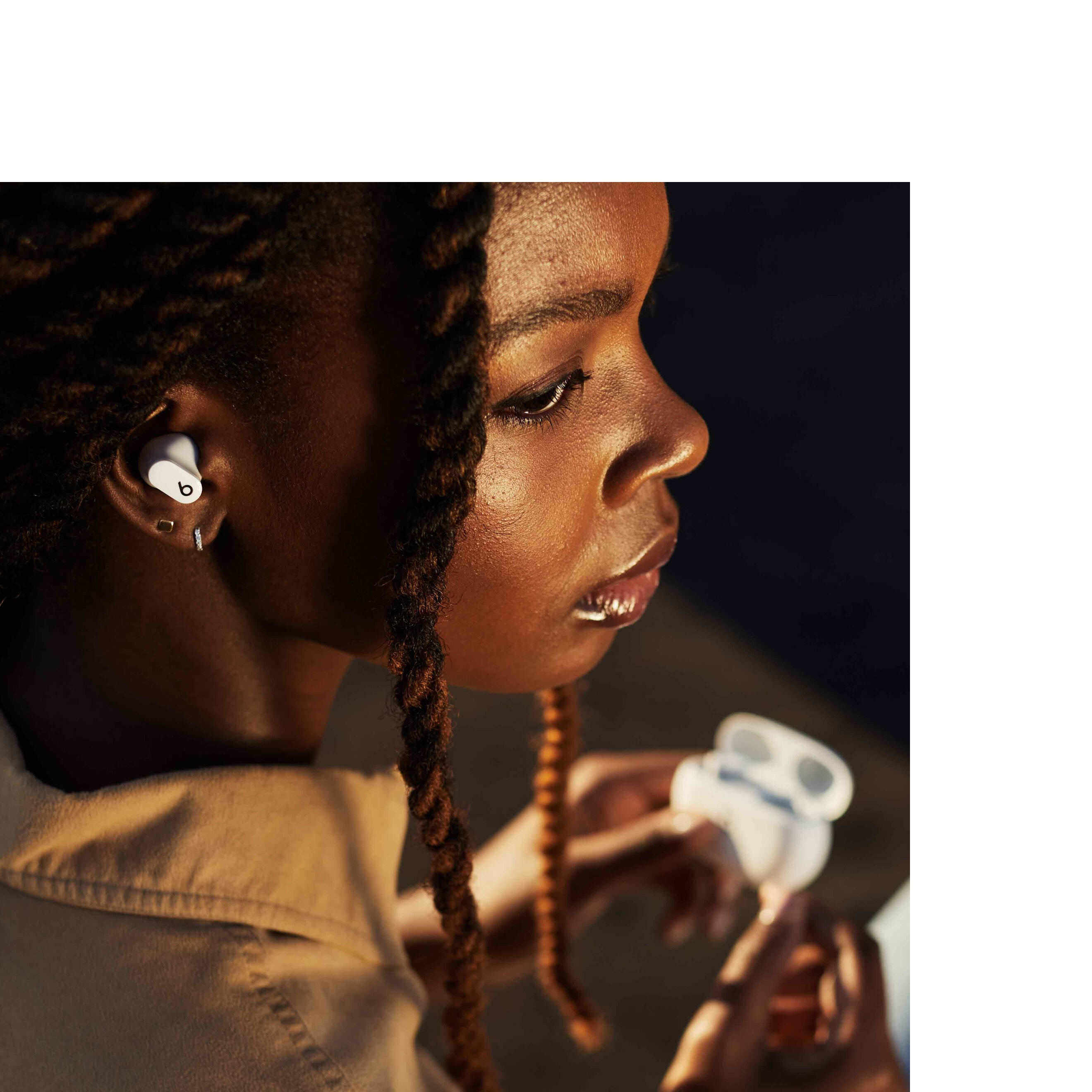 Girl in workout clothes resting with Powerbeats around her neck